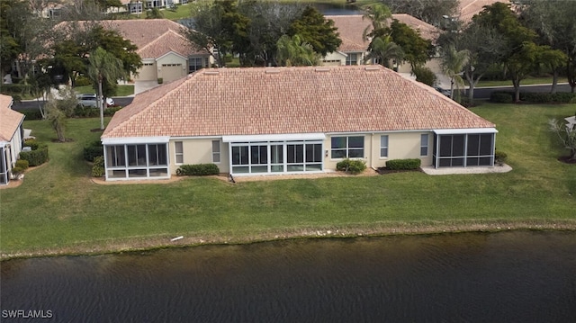 back of house featuring a yard, a sunroom, and a water view