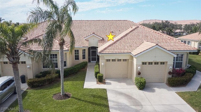 mediterranean / spanish-style home with a garage, a mountain view, and a front lawn