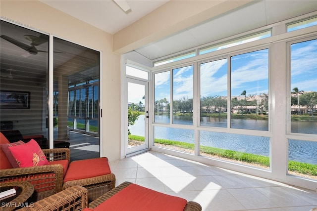 sunroom / solarium with ceiling fan and a water view