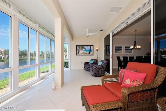 sunroom / solarium featuring a water view and an inviting chandelier