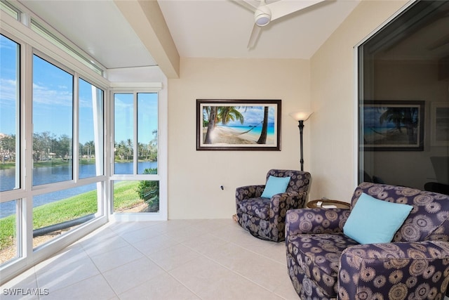 sitting room featuring light tile patterned flooring, a water view, plenty of natural light, and ceiling fan