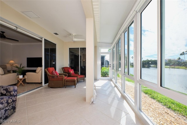 sunroom with a water view and ceiling fan