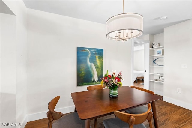 dining room with dark hardwood / wood-style flooring and a notable chandelier