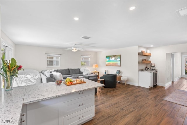 kitchen with light stone counters, white cabinets, and a healthy amount of sunlight