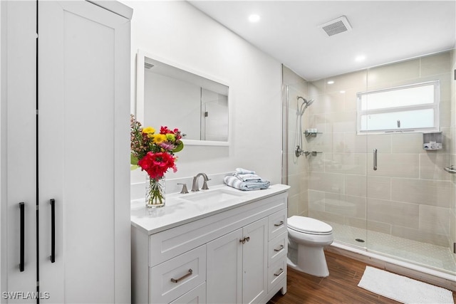 bathroom featuring hardwood / wood-style flooring, vanity, toilet, and an enclosed shower