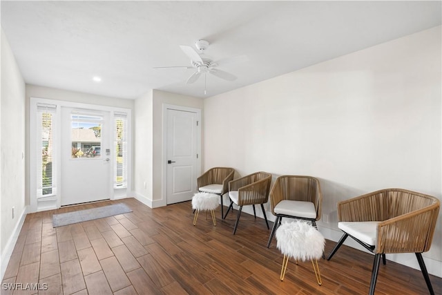 living area featuring dark hardwood / wood-style floors and ceiling fan