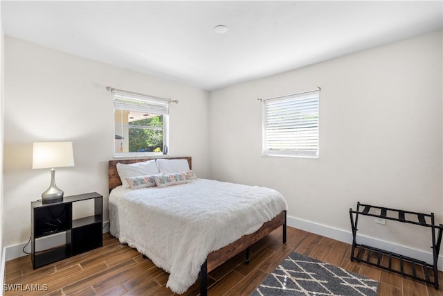 bedroom with dark hardwood / wood-style flooring