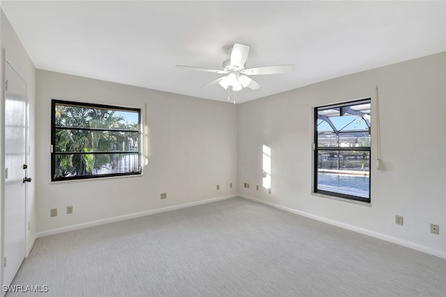 empty room featuring light colored carpet and ceiling fan