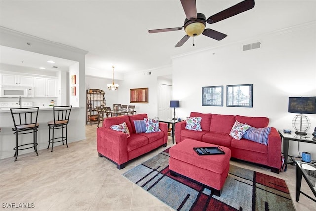 living room featuring crown molding, ceiling fan with notable chandelier, and light tile patterned floors