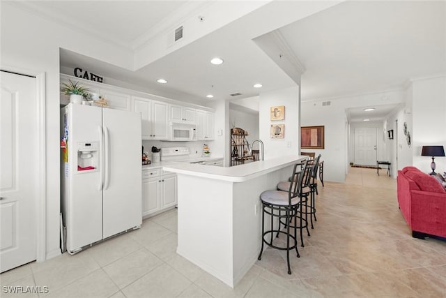 kitchen featuring crown molding, white appliances, a breakfast bar, and white cabinets