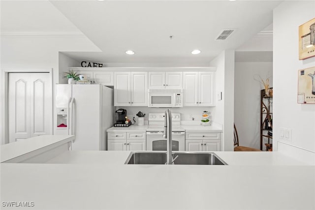 kitchen with crown molding, sink, white appliances, and white cabinets