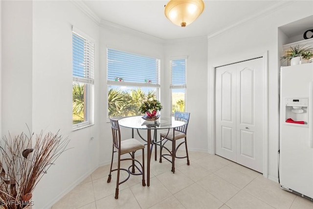 dining space featuring ornamental molding and light tile patterned floors