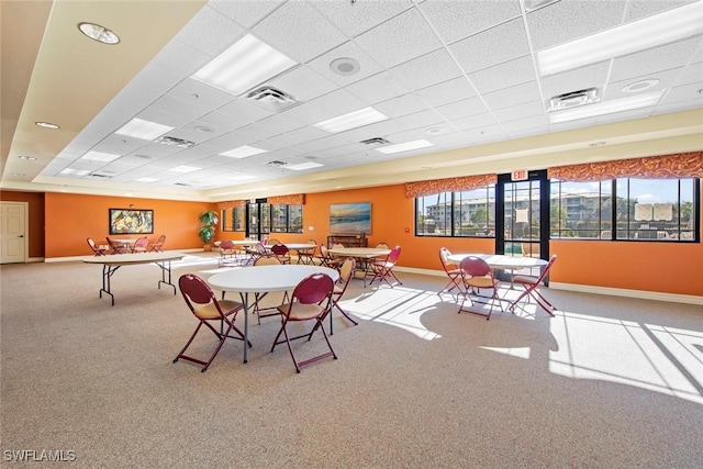 dining space with a paneled ceiling and carpet flooring