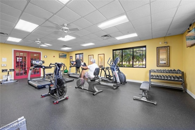 gym with a paneled ceiling and ceiling fan