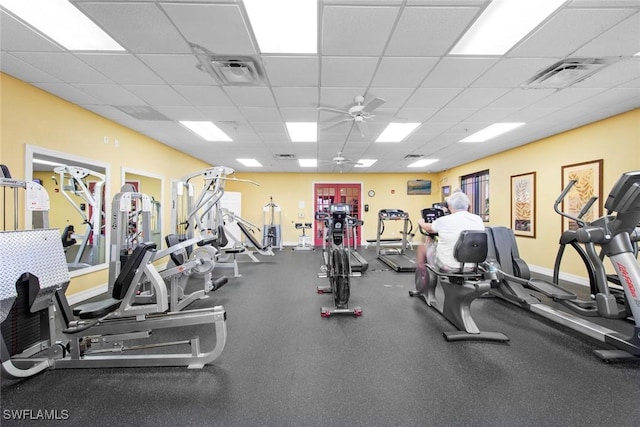 gym featuring ceiling fan and a paneled ceiling