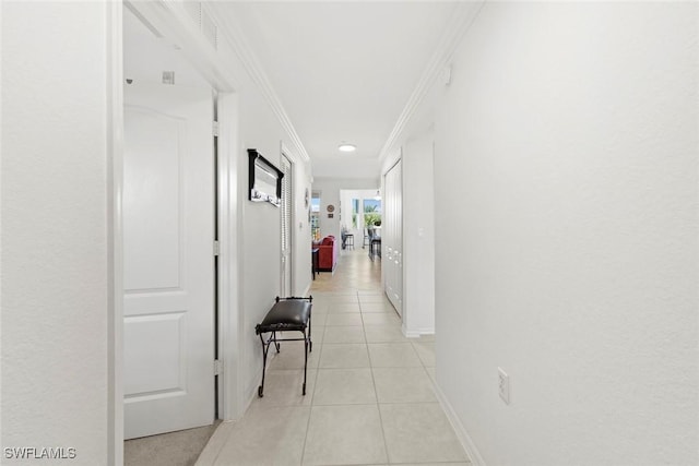 corridor with ornamental molding and light tile patterned floors