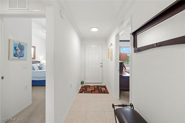 hall featuring ornamental molding and light tile patterned floors