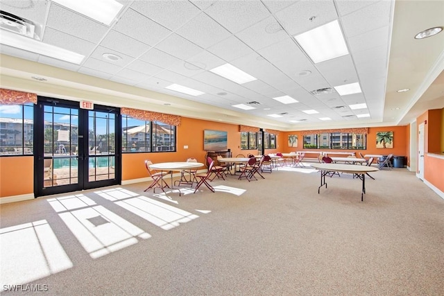 playroom with a paneled ceiling, light colored carpet, and french doors