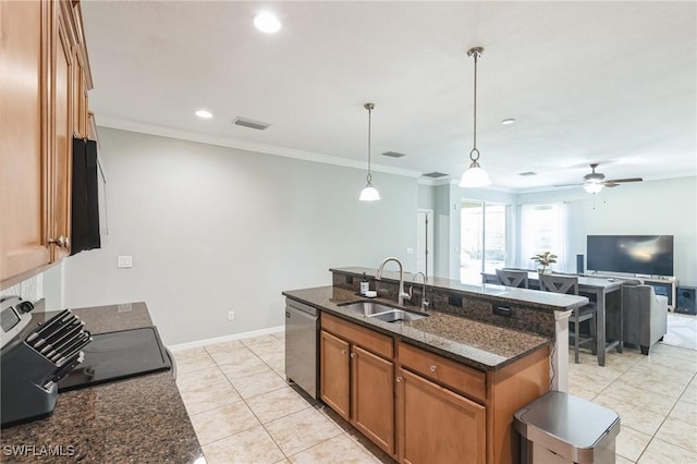 kitchen featuring sink, stainless steel dishwasher, pendant lighting, dark stone counters, and a kitchen island with sink