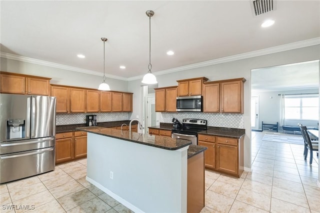 kitchen with ornamental molding, stainless steel appliances, a kitchen island with sink, and light tile patterned floors