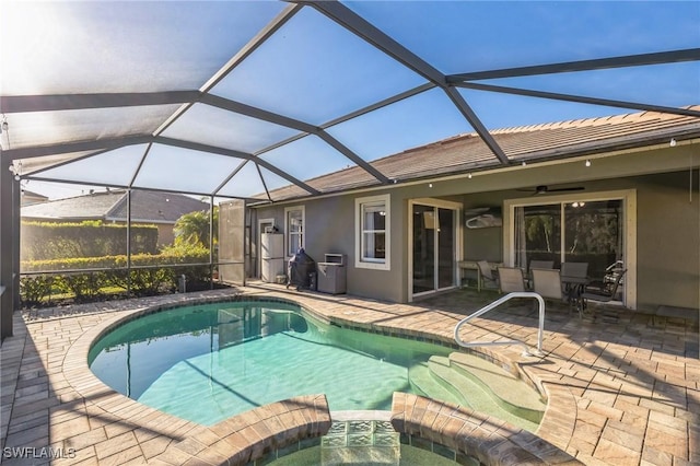 view of swimming pool featuring a lanai, a patio, ceiling fan, and an in ground hot tub