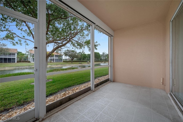 unfurnished sunroom with a water view