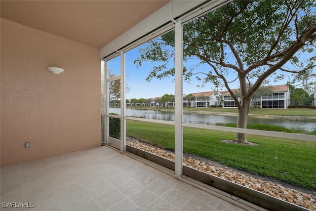 unfurnished sunroom with a water view