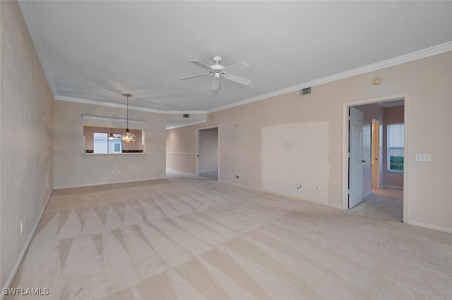 empty room featuring crown molding, light colored carpet, and ceiling fan