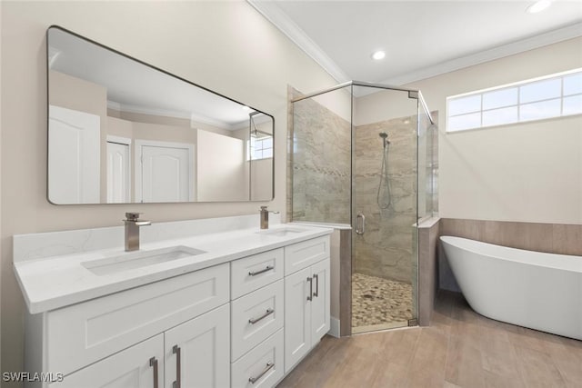 bathroom with ornamental molding, separate shower and tub, hardwood / wood-style floors, and vanity