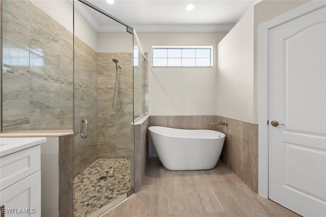 bathroom with crown molding, separate shower and tub, wood-type flooring, and vanity