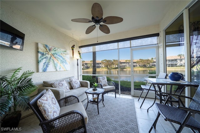 sunroom / solarium featuring a water view and ceiling fan