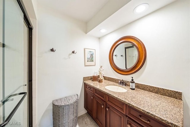 bathroom featuring walk in shower, vanity, and tile patterned flooring