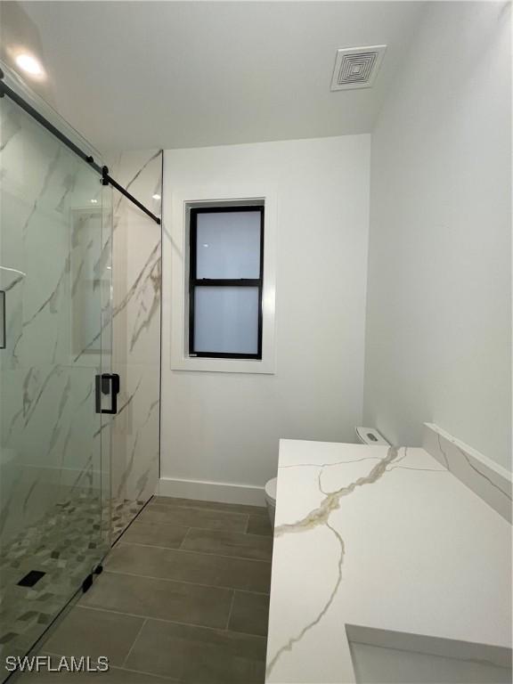 bathroom with toilet and walk in shower