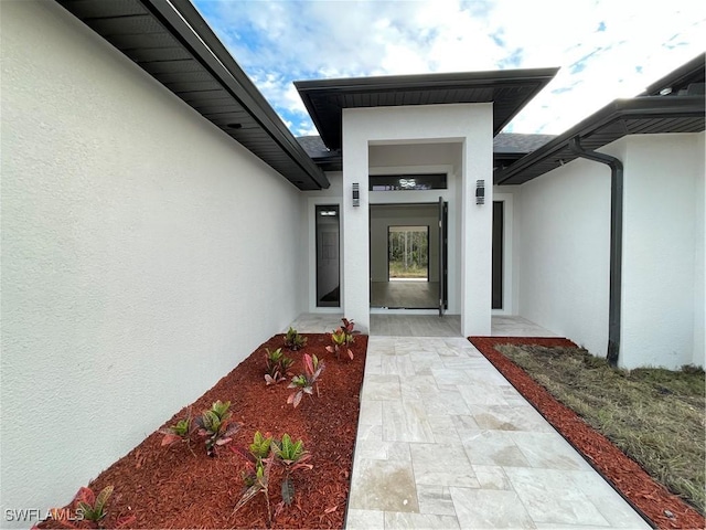 view of exterior entry featuring a patio area