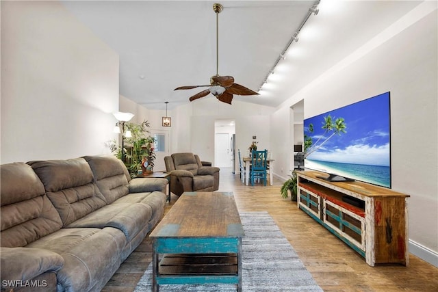 living room with track lighting, baseboards, lofted ceiling, wood finished floors, and a ceiling fan