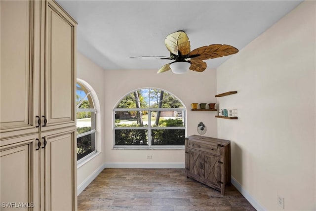 interior space with light wood-type flooring, baseboards, and ceiling fan