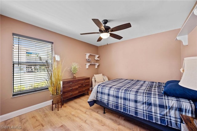 bedroom with baseboards, light wood finished floors, and ceiling fan