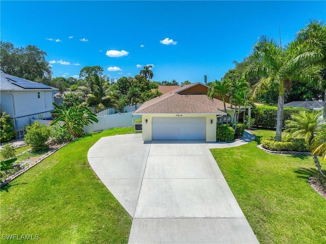 mediterranean / spanish-style house with an attached garage, fence, a front yard, stucco siding, and driveway