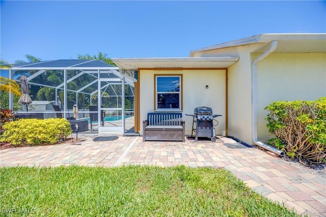 view of patio / terrace with glass enclosure and a grill