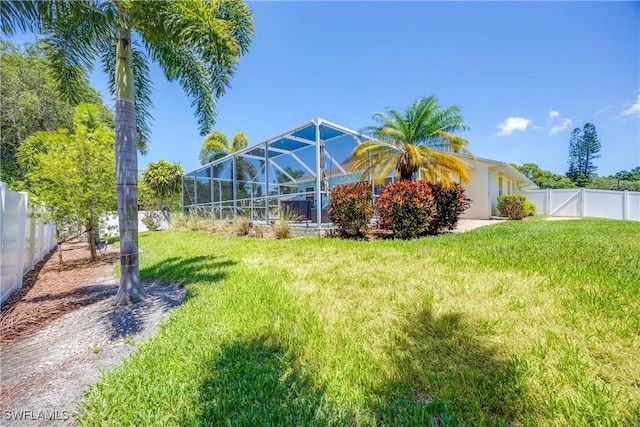 view of yard featuring glass enclosure and a fenced backyard