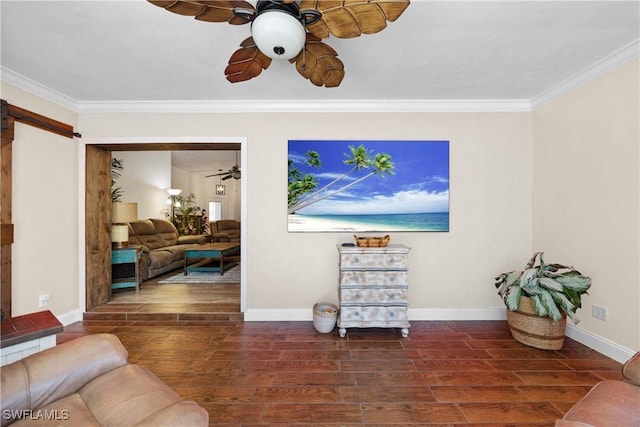 living area featuring wood finished floors, a ceiling fan, baseboards, crown molding, and a barn door