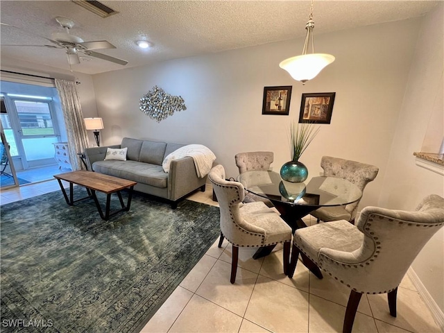 tiled dining space featuring ceiling fan and a textured ceiling