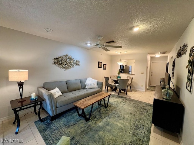 tiled living room with ceiling fan and a textured ceiling