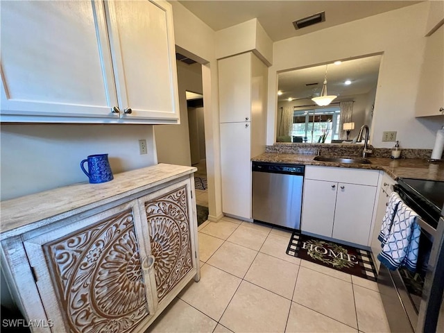 kitchen with pendant lighting, sink, white cabinets, light tile patterned floors, and stainless steel appliances