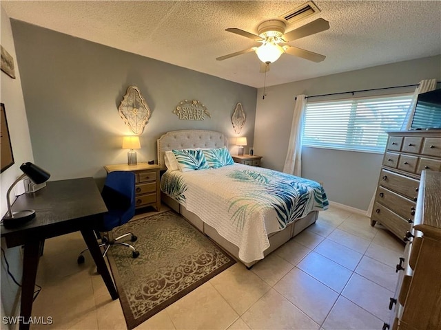 tiled bedroom featuring a textured ceiling and ceiling fan