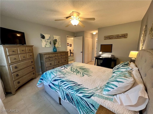 tiled bedroom featuring a textured ceiling, a closet, and ceiling fan