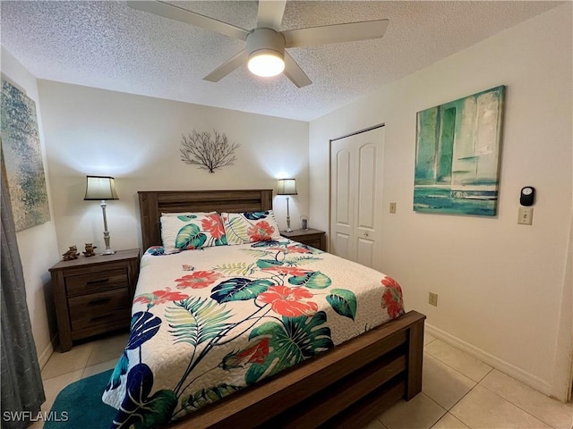 tiled bedroom featuring a textured ceiling, ceiling fan, and a closet