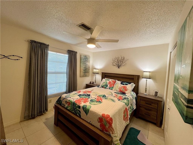 tiled bedroom with a textured ceiling and ceiling fan