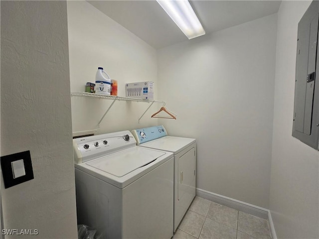 clothes washing area with light tile patterned floors, electric panel, and washer and dryer