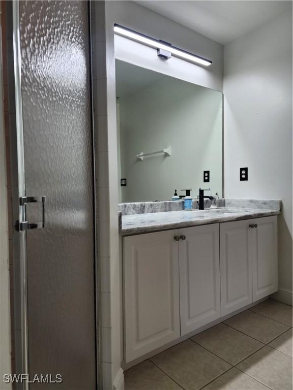 bathroom featuring tile patterned flooring, vanity, and walk in shower